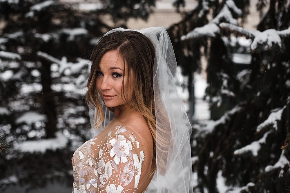 Bride poses by the snow capped trees in front of Scioto Reserve Country Club