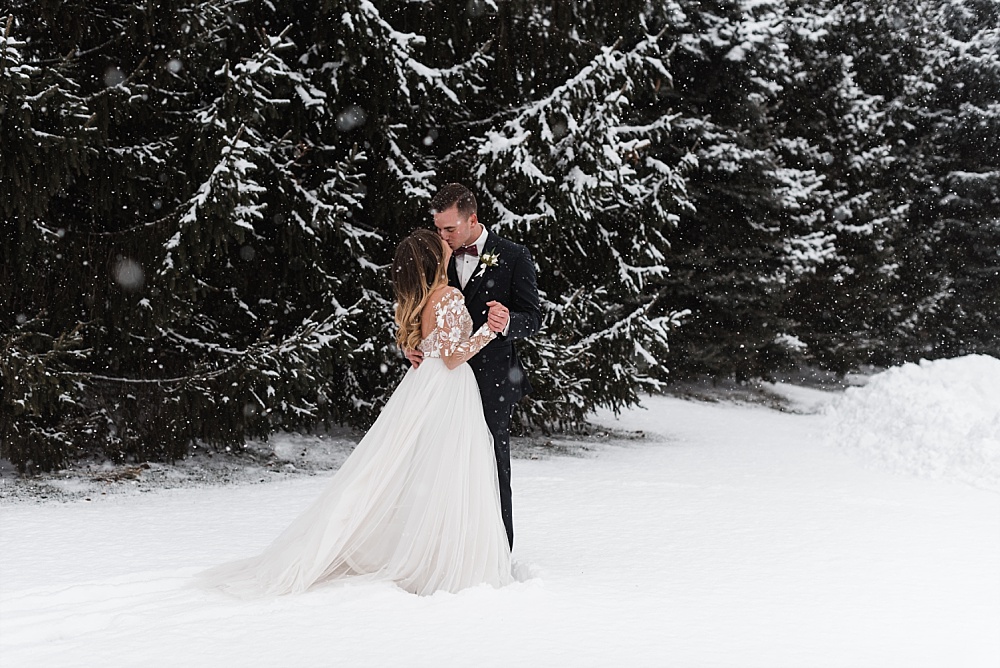 Bride and groom pose for portraits in the snow at Scioto Reserve Country club during their winter wedding