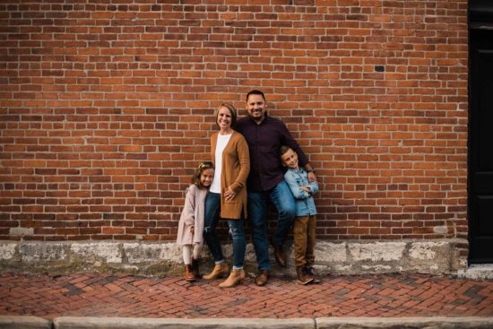 Family posing against a brick wall