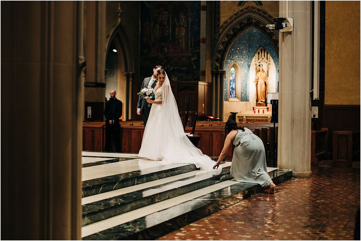 bridesmaid fixes brides dress at altar