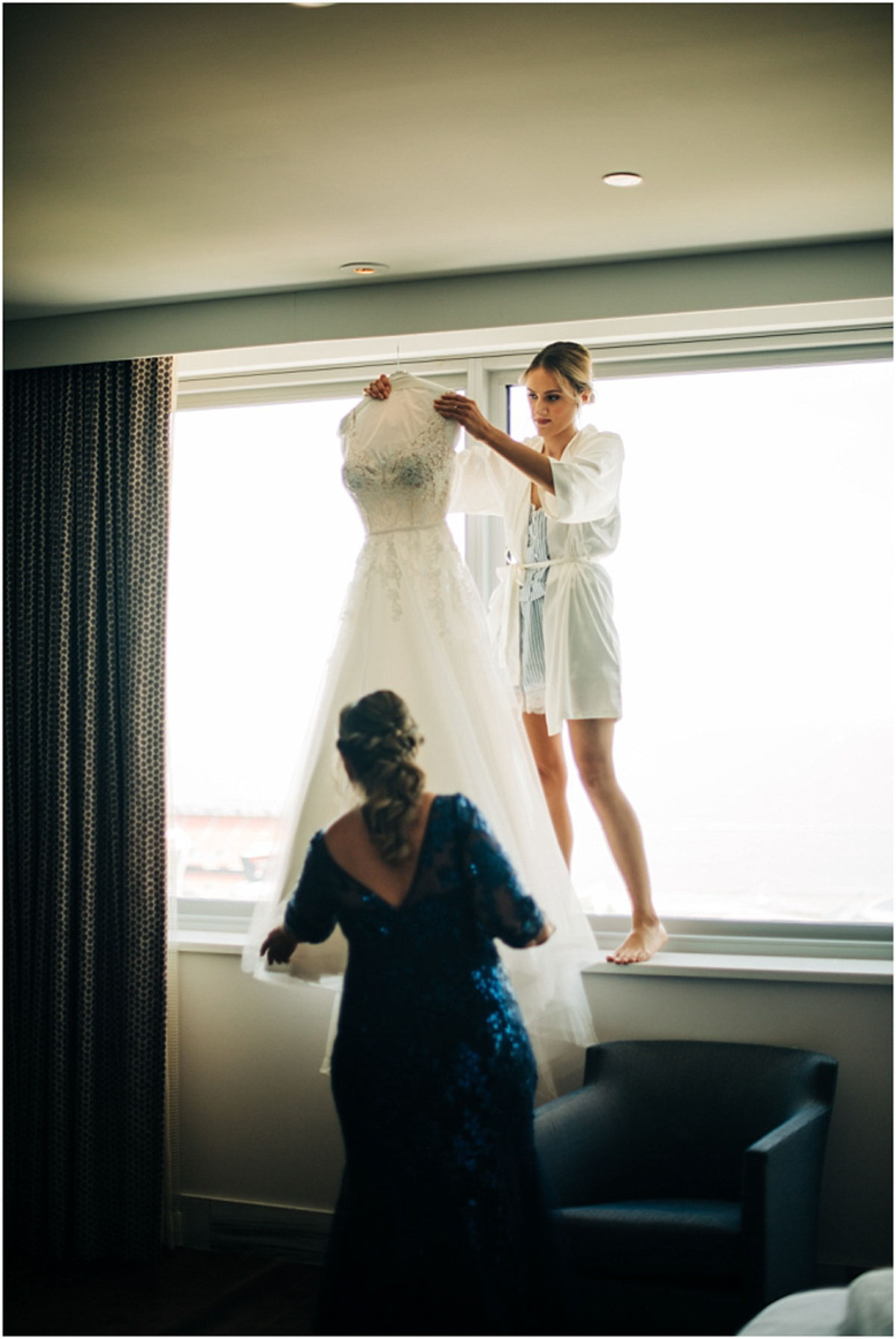 bride getting her wedding dress down from hanger
