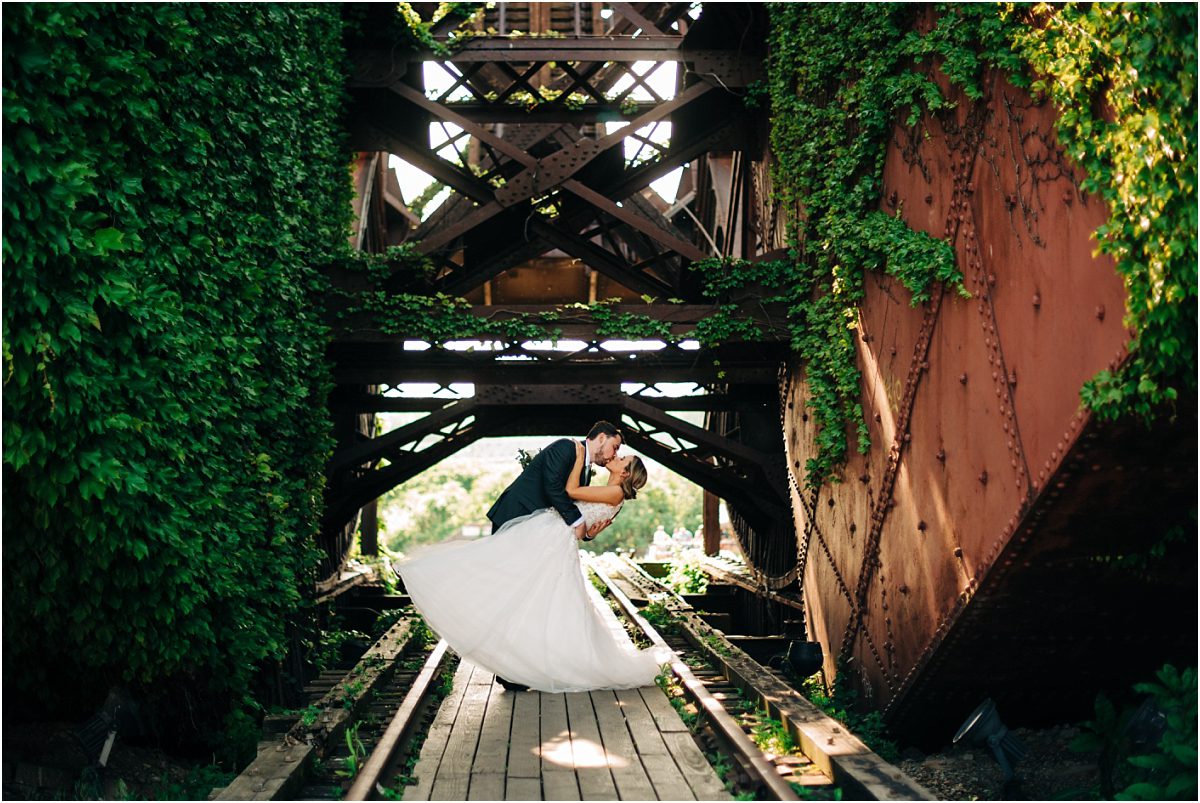 bride and groom dip on a mossy bridge