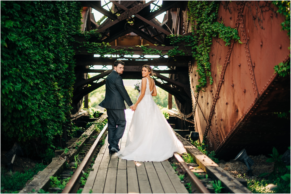 bride and groom walk away on bridge in cleveland ohio