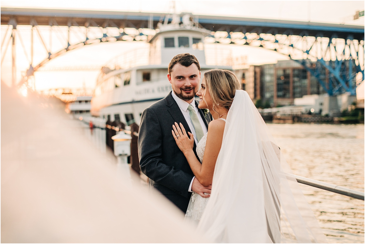 Groom looks into camera during sunset