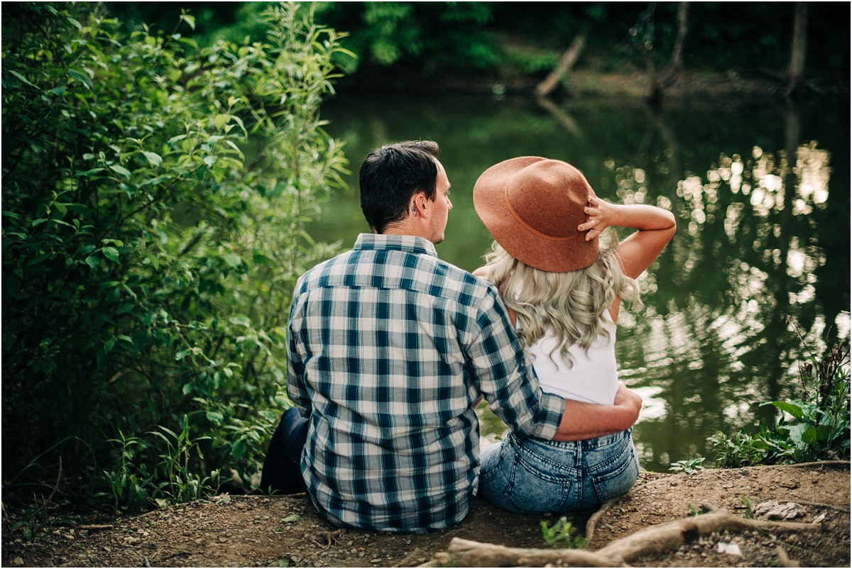 Couple sits by water for their engagement pictures