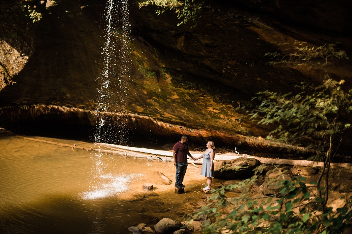A man and woman holding hands for their engagement session at Old Man's Cave