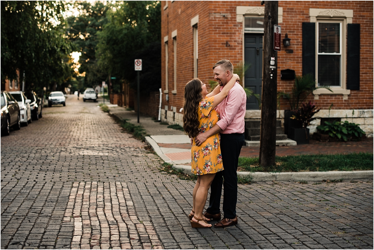 couple stands in street for engagement photos