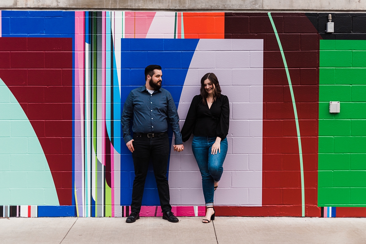 couple leans against a painted wall in the short north
