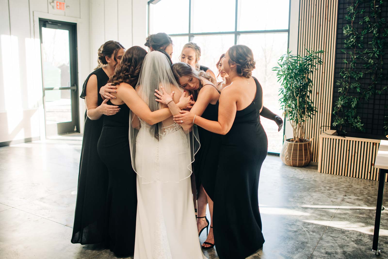 bride and her bridesmaids hugging at Retreat 21 wedding