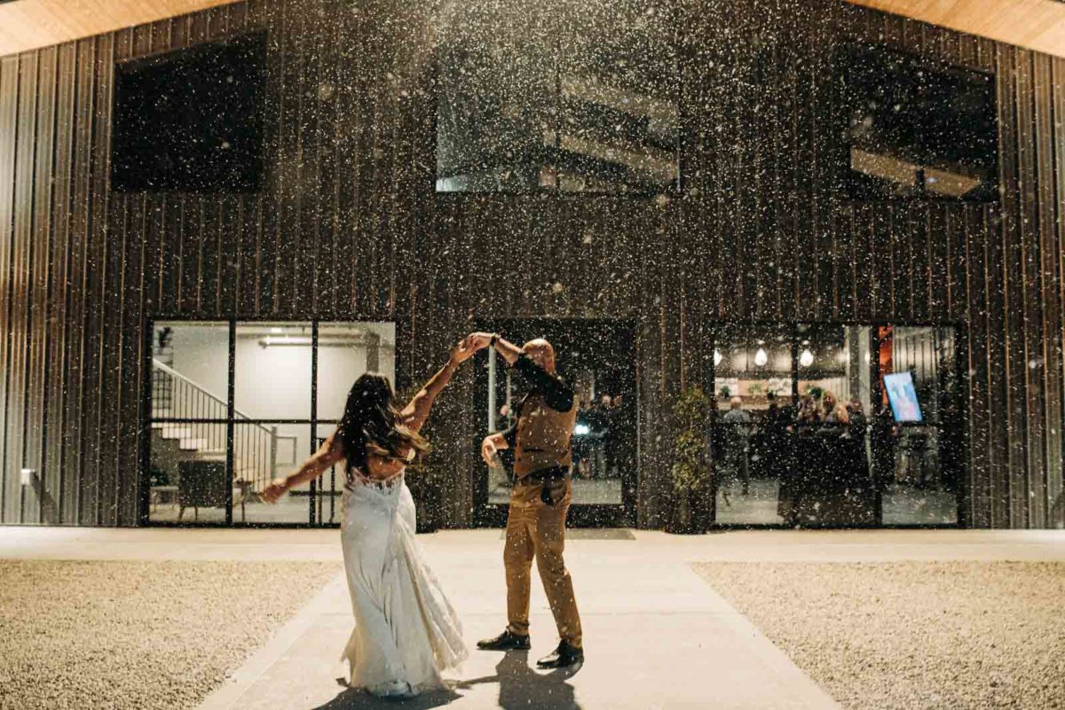 Groom twirls his bride in front of Retreat 21 wedding venue