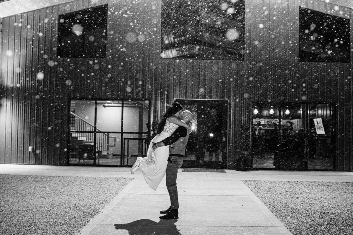 Black and white image of a groom lifting his bride for a kiss at Retreat 21 in Marysville, Ohio