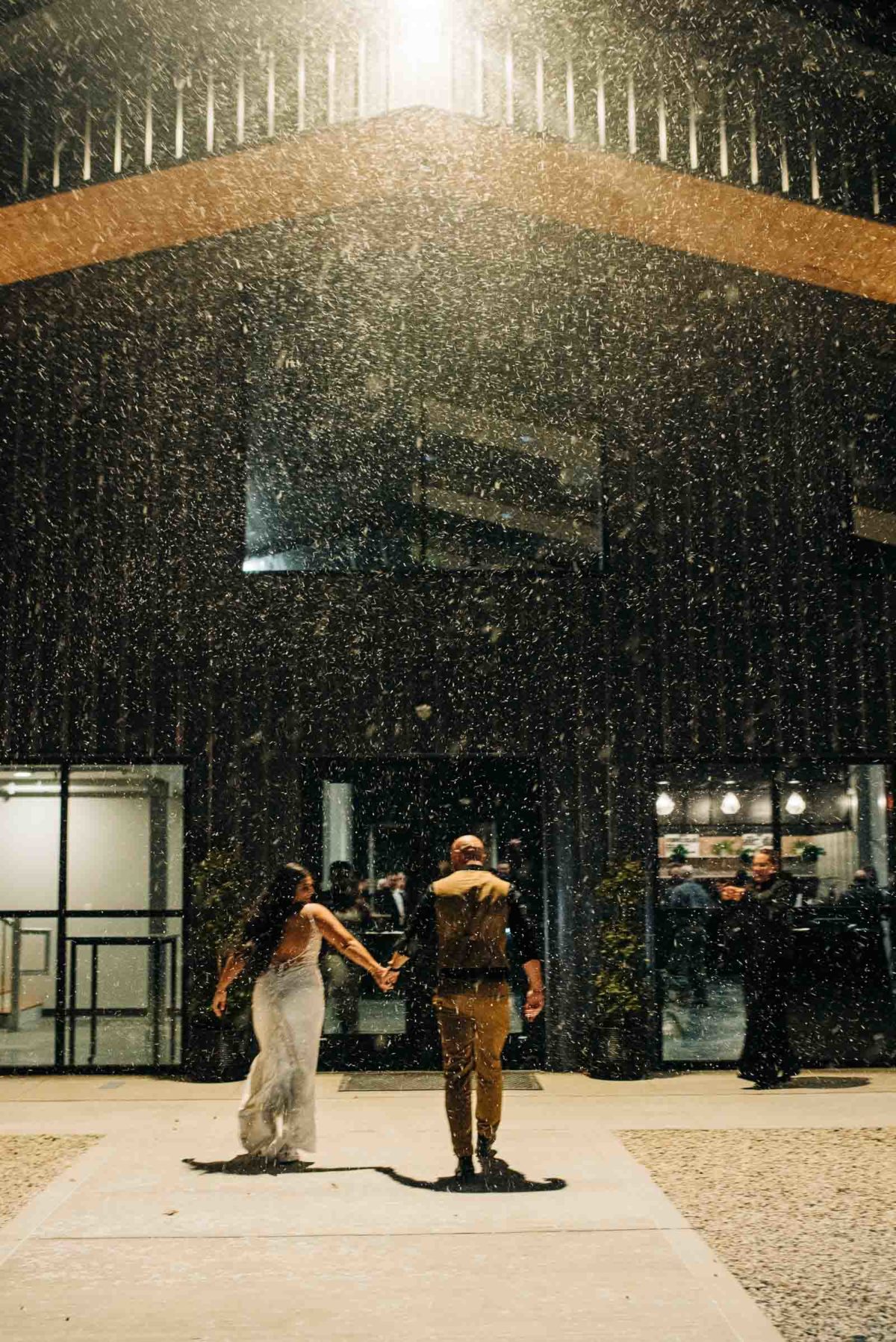 Bride and groom running inside while it snows at their Retreat 21 wedding