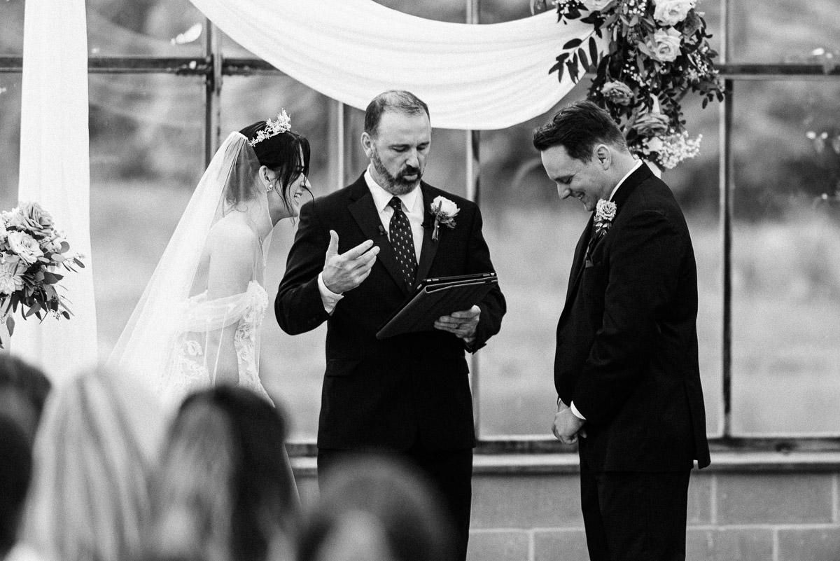 Bride and groom giggle during their vows at their Oak Grove wedding