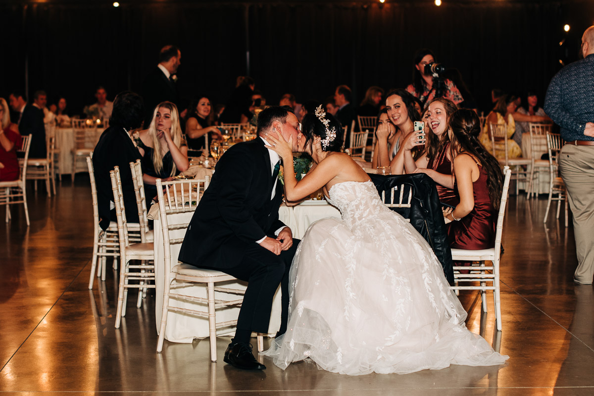 Bride and groom share a kiss at their reception at Oak Grove wedding venue