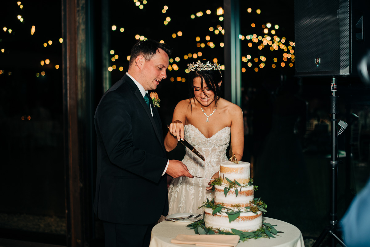Bride and groom cut their wedding cake at Oak Grove during their recepetion