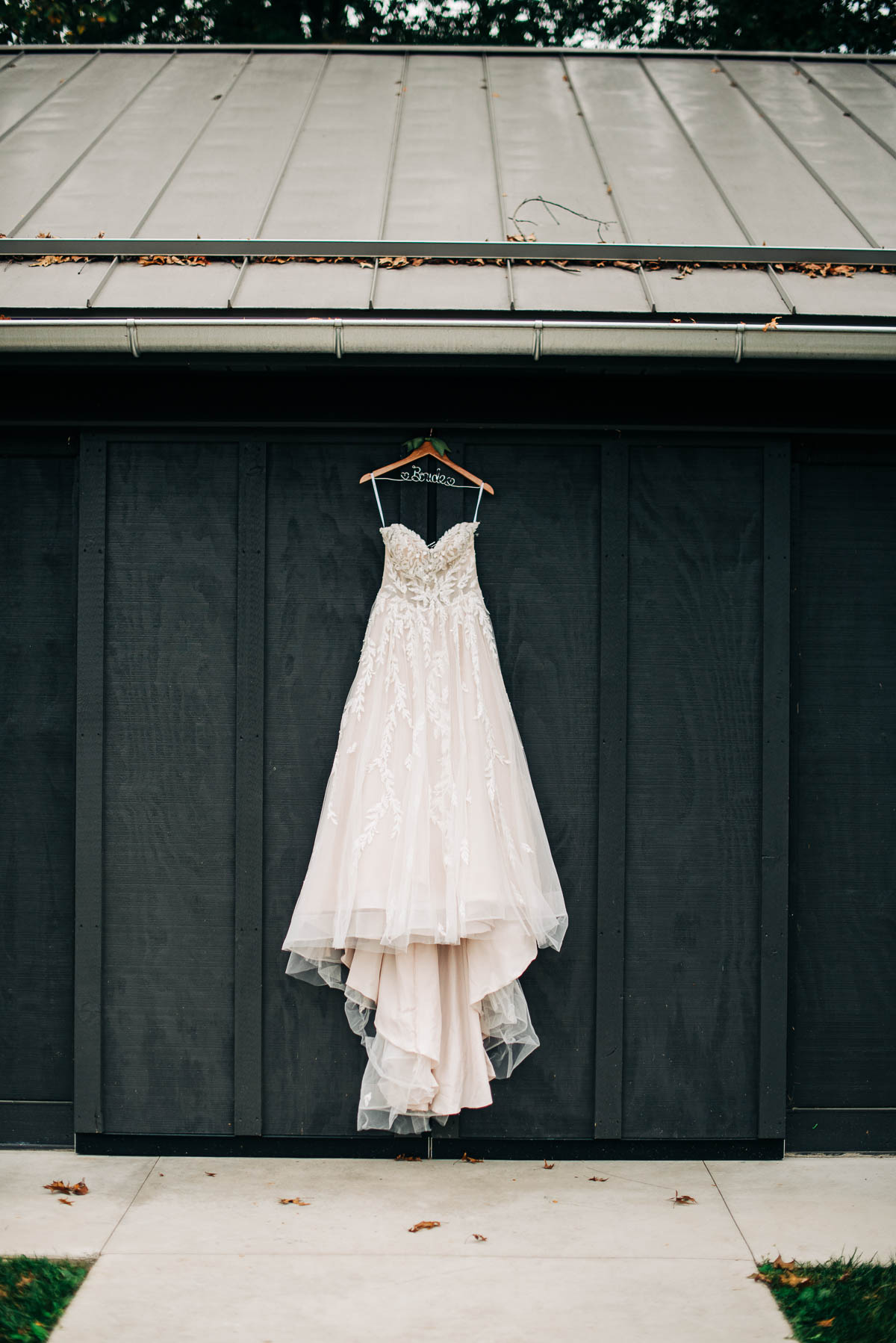Bride's wedding dress hanging on an outbuilding at Jorgensen's Oak Grove