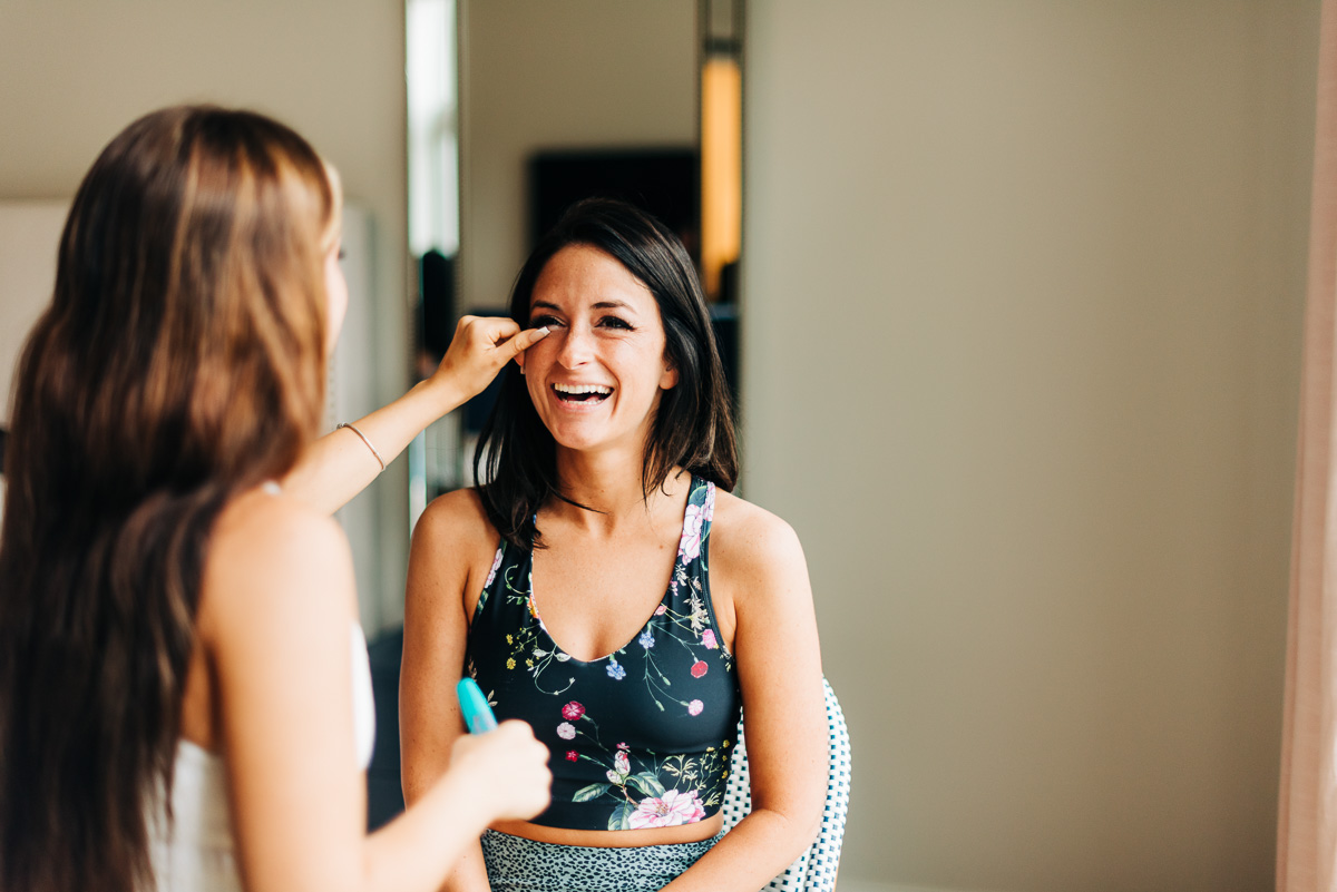 bride laughs while getting ready