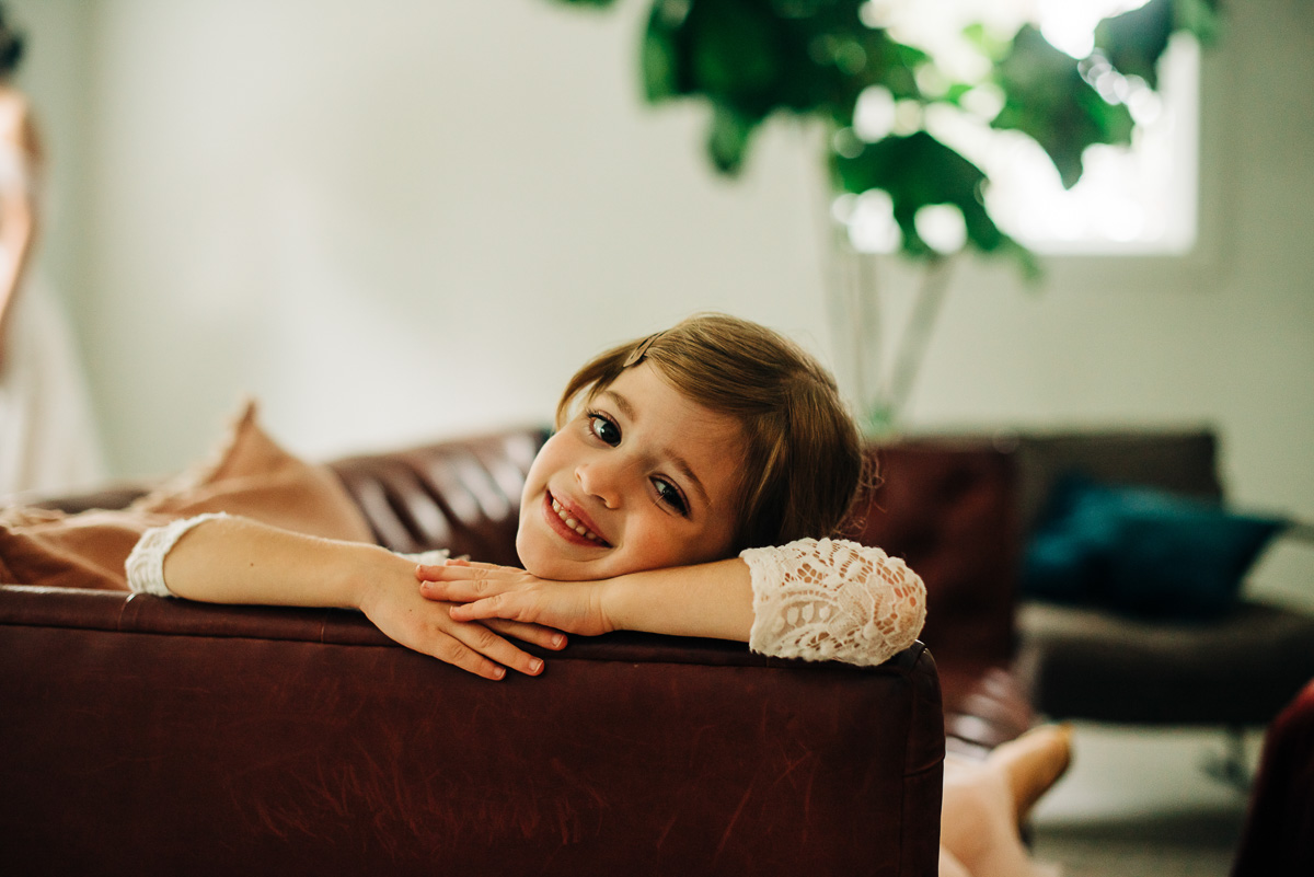 Flower girl poses on the couch