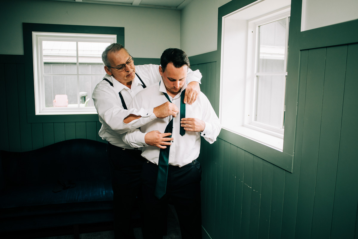 Groom's father helping him get ready for his wedding