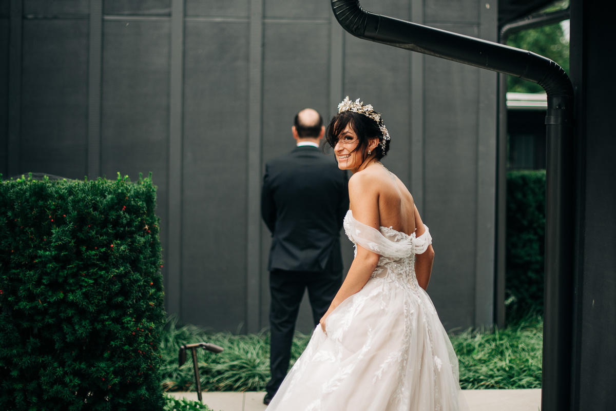 Brides looks back before approaching her dad for the father of the bride first look