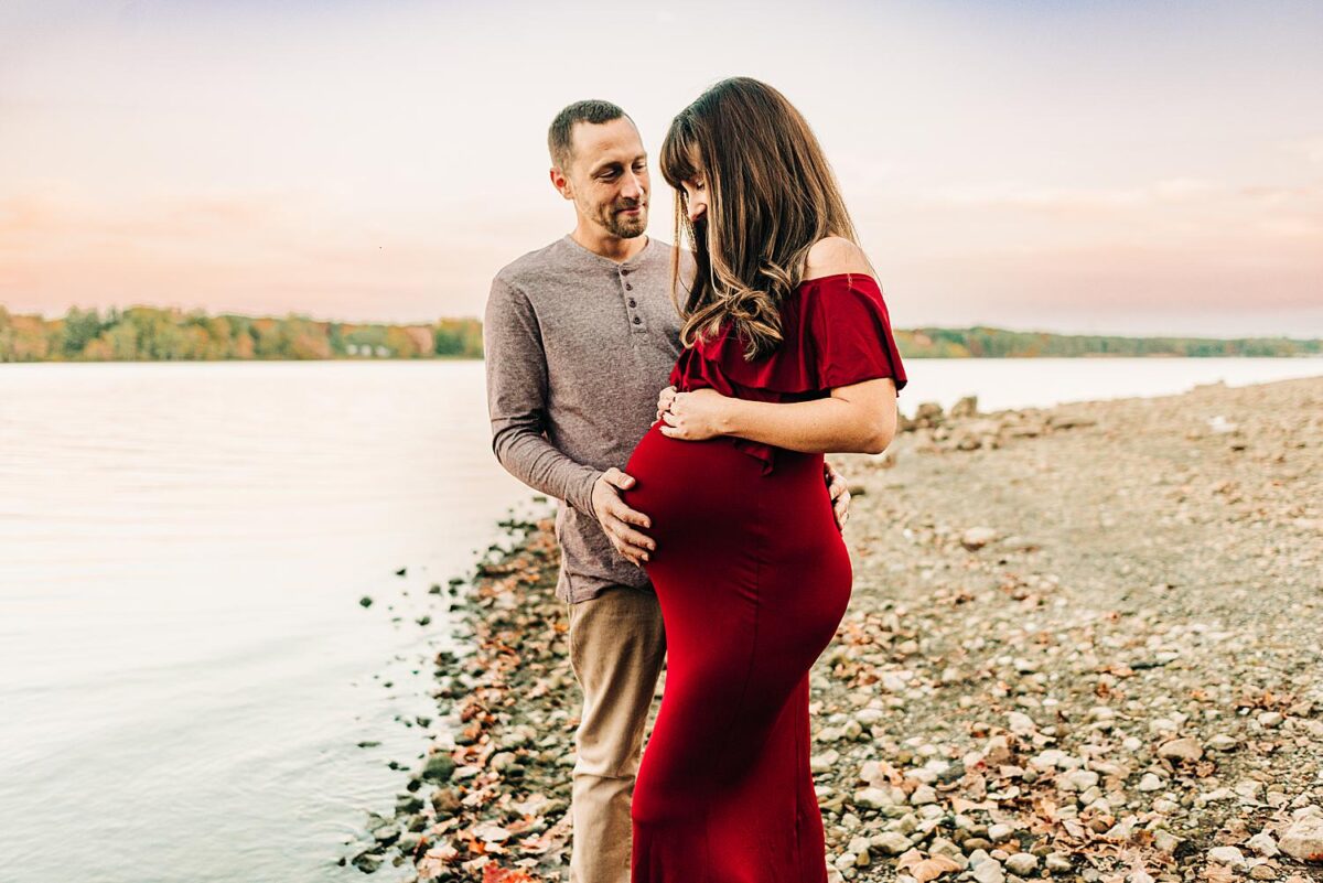 Columbus Ohio maternity photographer poses couple in front of tranquil waters of Hoover Reservoir