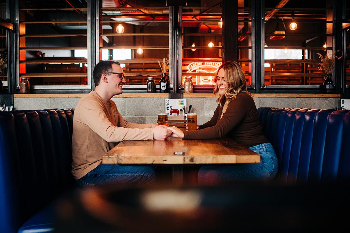 Couple sits at table for their engagement session