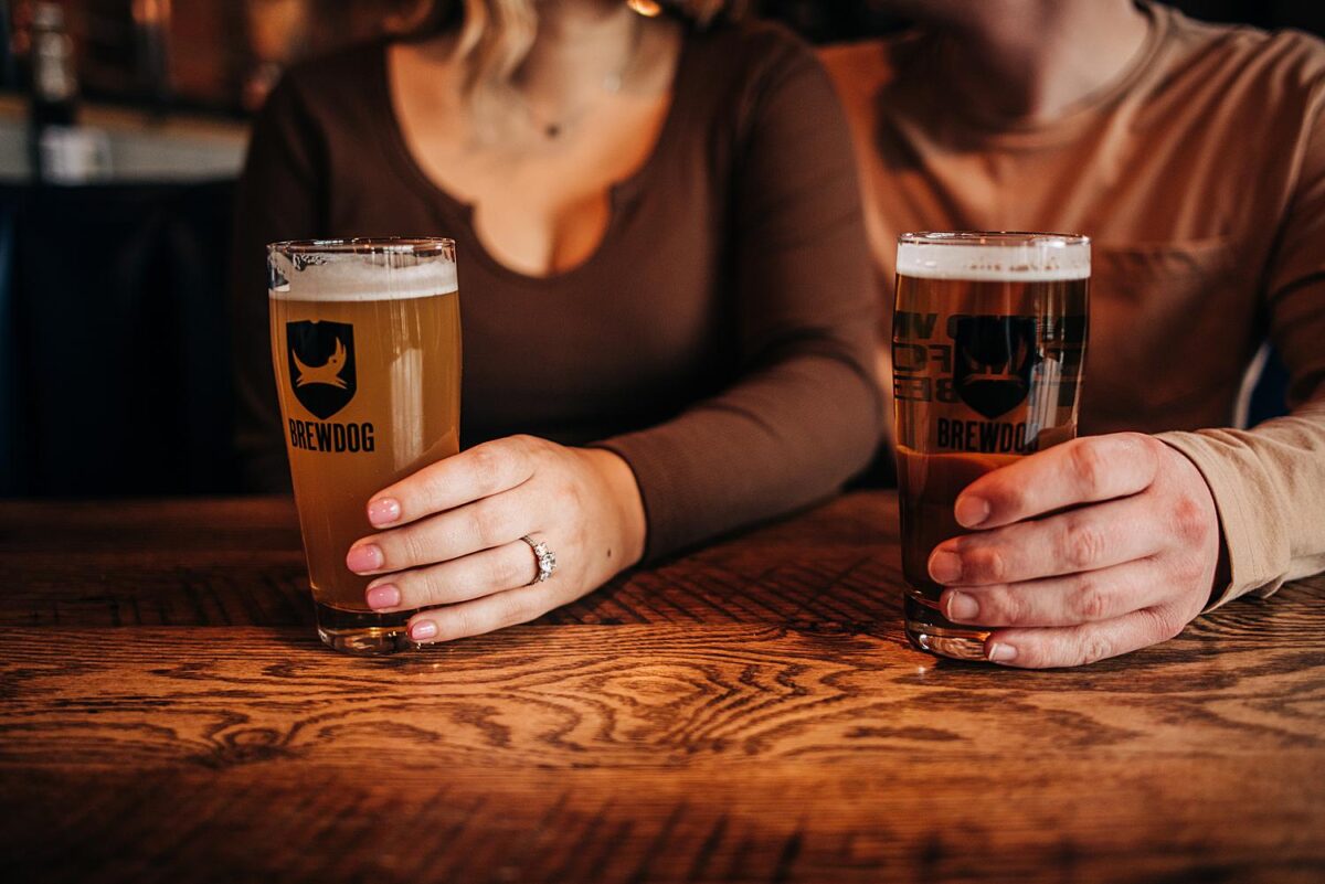 Close up of newly engaged couple holding onto their beer mugs at Brewdog Franklinton in Columbus, Ohio