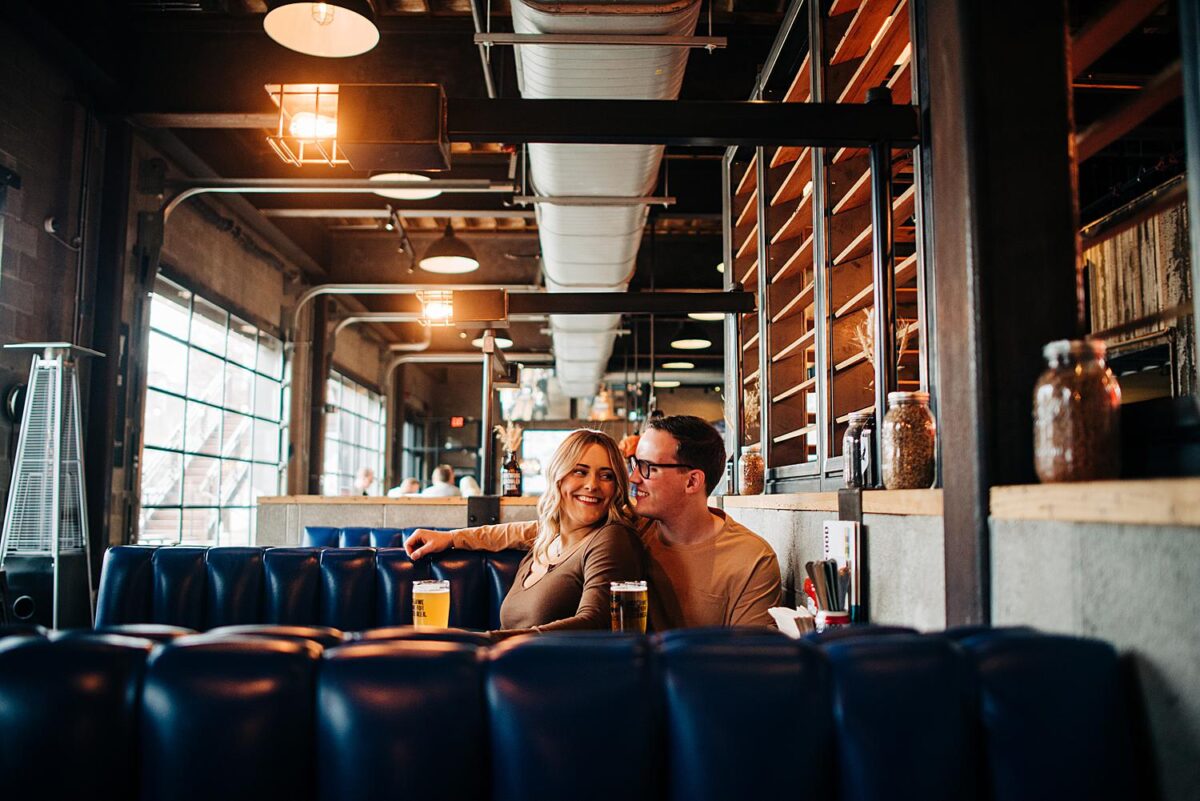 Engaged couple share a booth at Brewdog Franklinton for their engagement photoshoot 