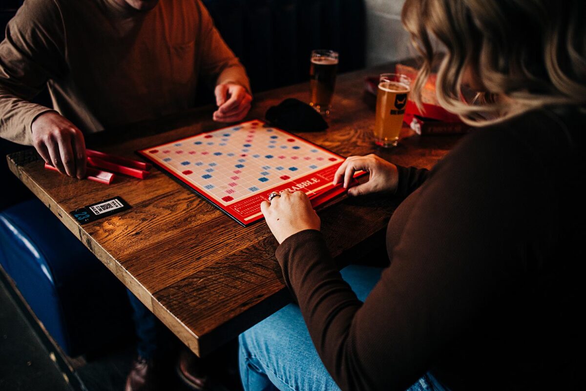 Couple plays scrabble during their engagement photos