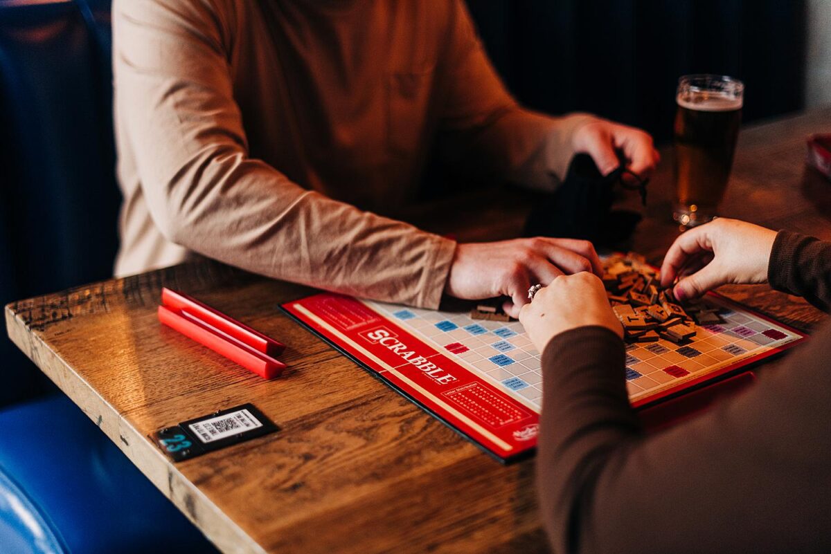 Couple plays scrabble during their engagement photos