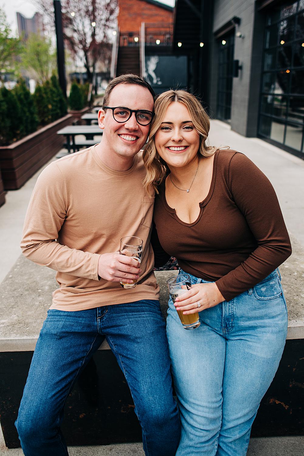 Newly engaged couple smile for a portrait outside of Brewdog Franklinton in Columbus, Ohio
