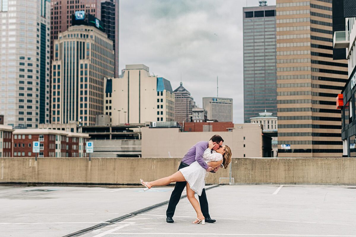 Newly engaged couple kiss on top of a parking garage in Downtown Columbus