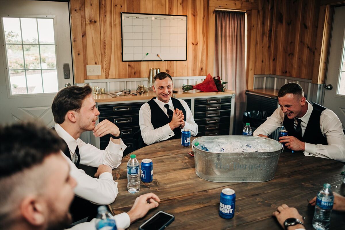 Groom and groomsmen hang out in the grooms suite at the Flora and Field wedding venue