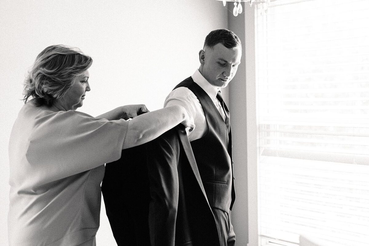 Mother of the groom helps her son prepare for his wedding day at Flora and Field