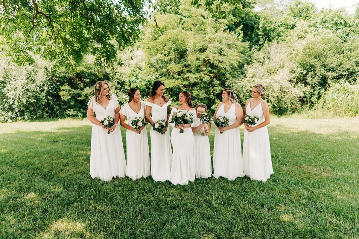 Bridesmaids laugh amongst each other during portraits with their wedding photographer