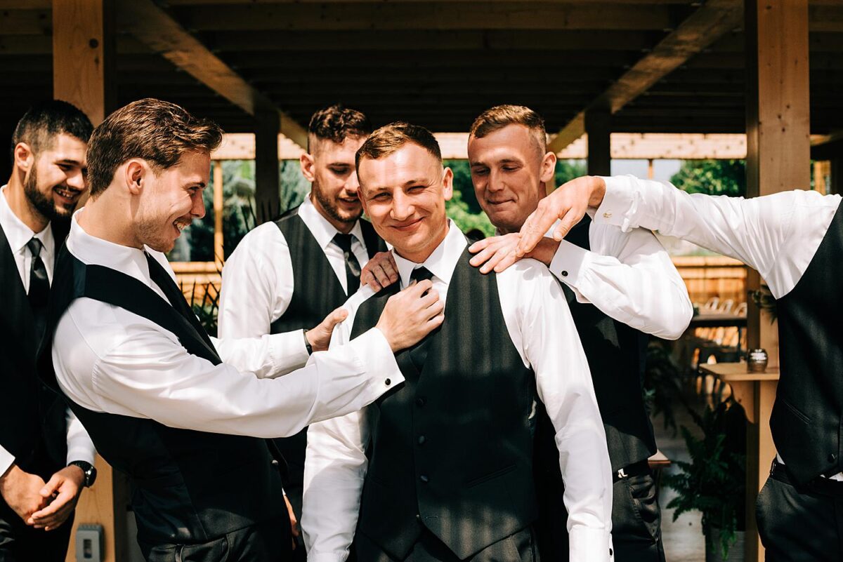 Groom and groomsmen goof off during their portraits with wedding photographers 