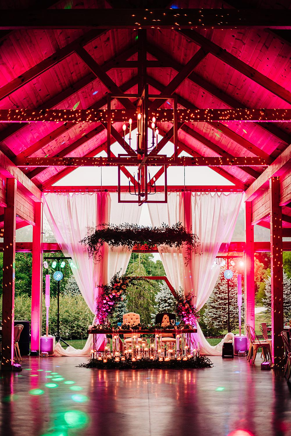 Flora and Field wedding reception space with dramatic pink uplighting
