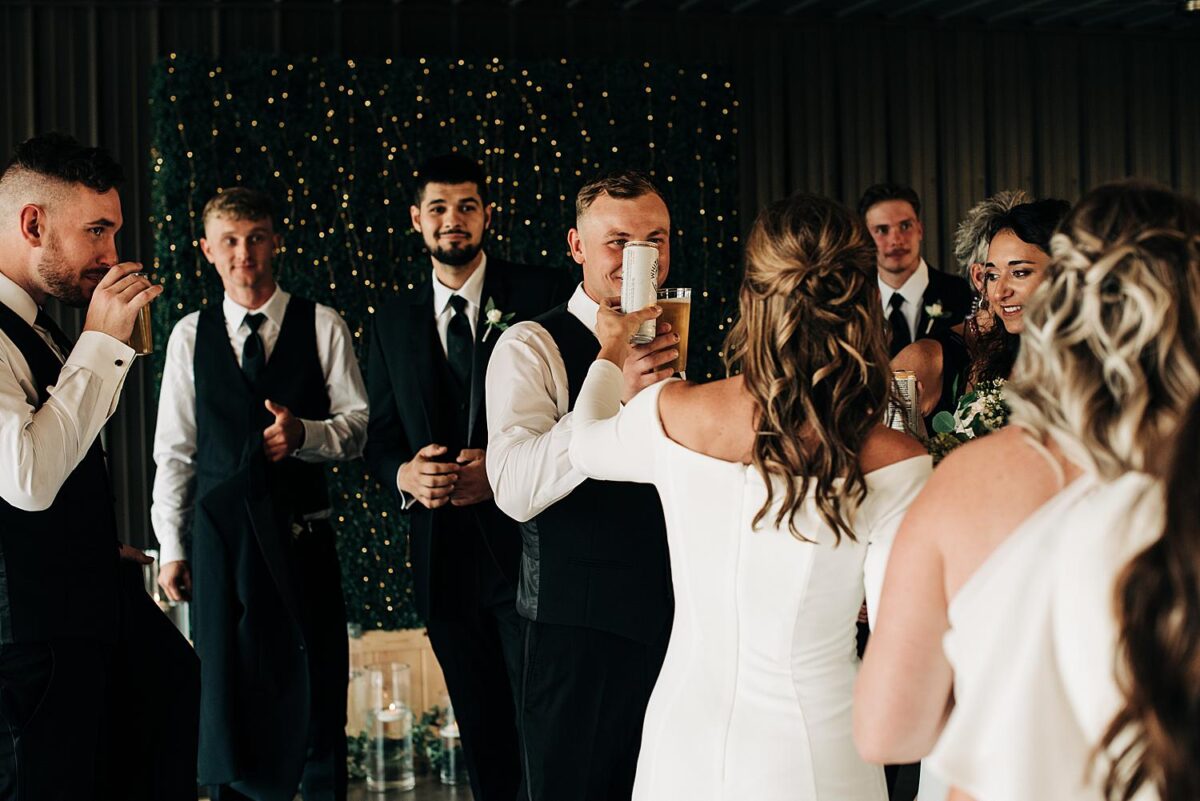 Bride and groom cheer their drinks after tying the knot at their Flora and Field wedding