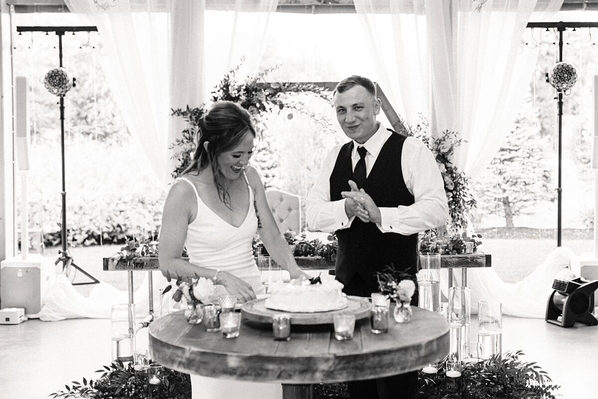 Bride and groom giggle over their cake cutting