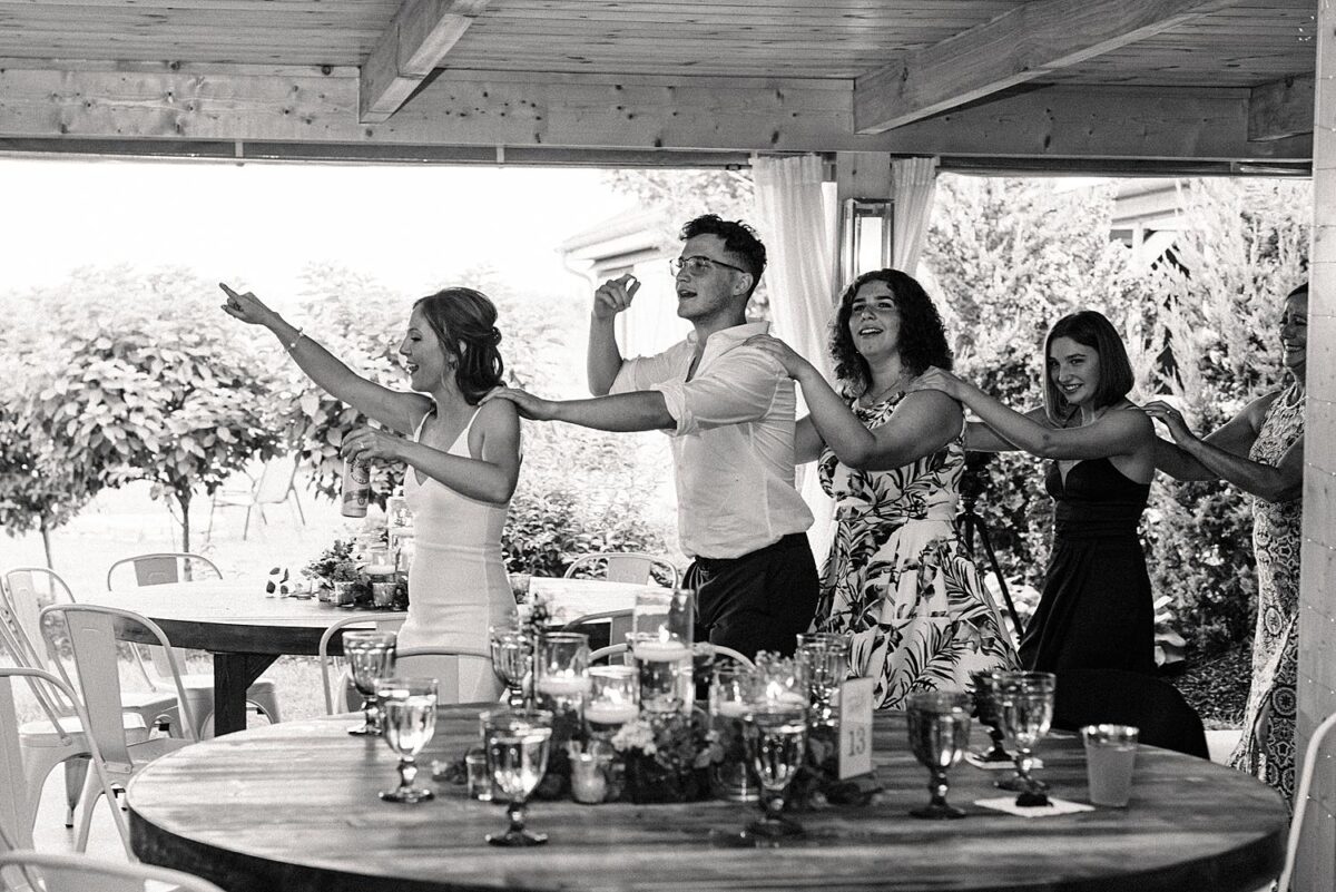 Wedding guests laugh while dancing during reception at Flora and Field