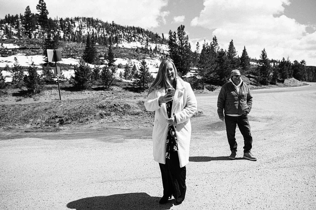 Mother of bride smiles at her daughter while she gets dressed for her elopement in the parking lot at Sapphire Point Overlook in Dillon, Colorado.