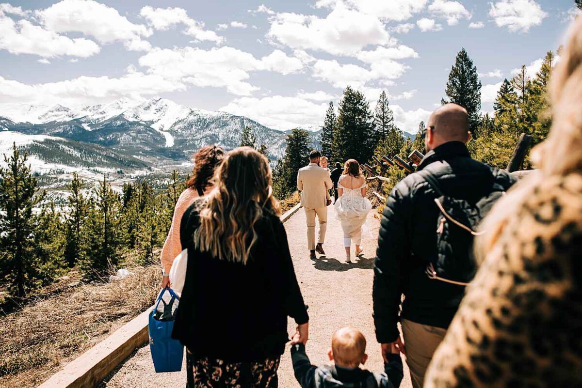 Wedding couple and their family members walk towards the ceremony space at Sapphire Point Overlook