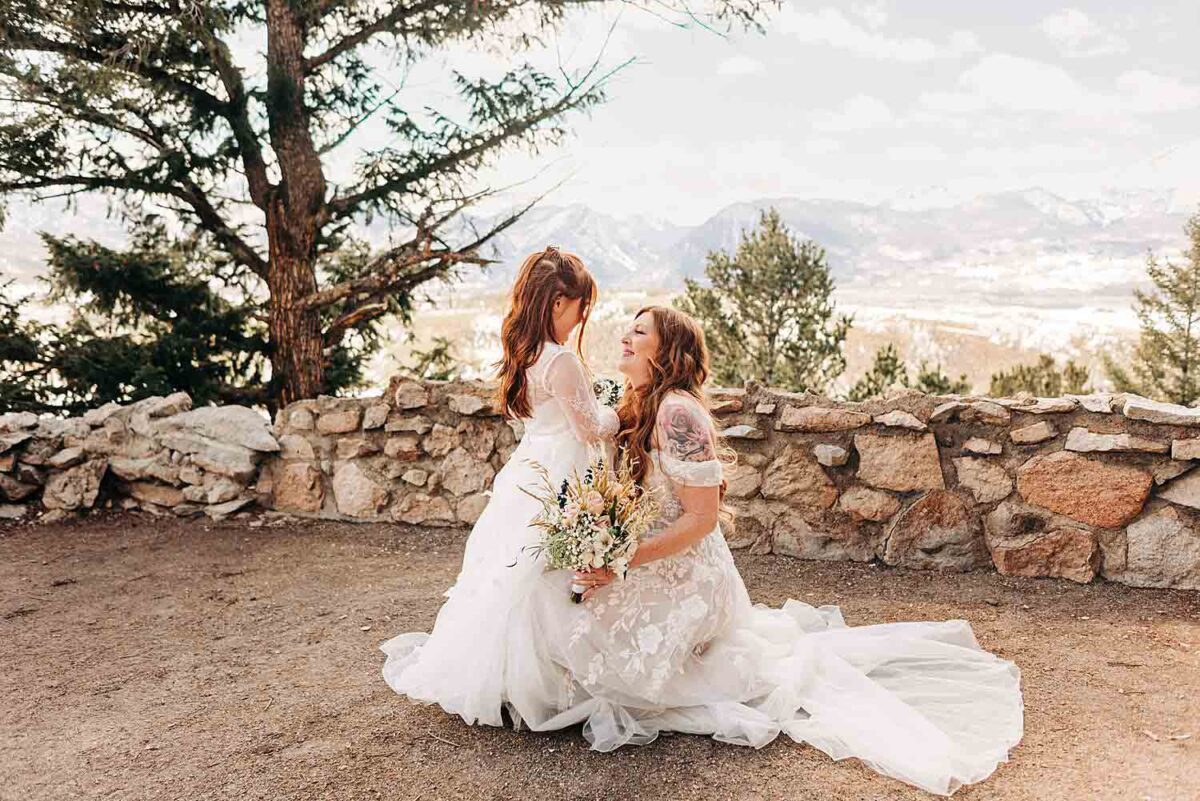 Bride and her daughter embrace in front of the mountain views at Sapphire Point Overlook