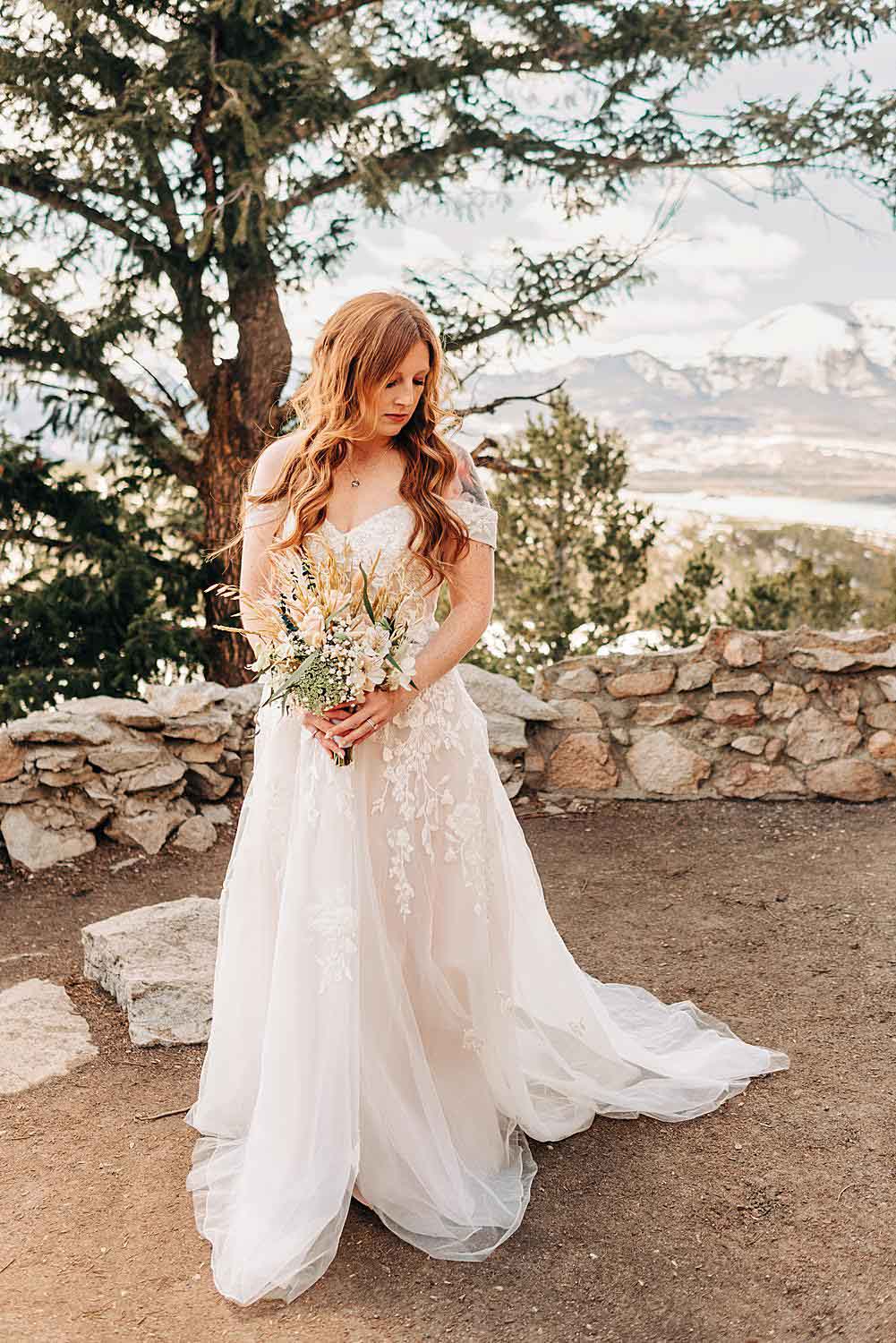 Bride poses for a portrait at Sapphire Point Overlook in Dillon, Colorado